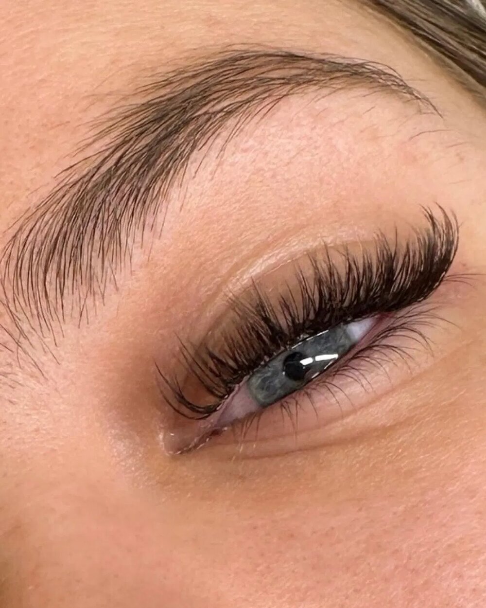 Close up of a full set of Russian volume lash extensions with a shaped brow